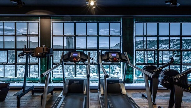 A gym with treadmills, a stationary bike, and a rowing machine, with large windows overlooking a snowy landscape. - Akademiehotel Jena (Jena)
