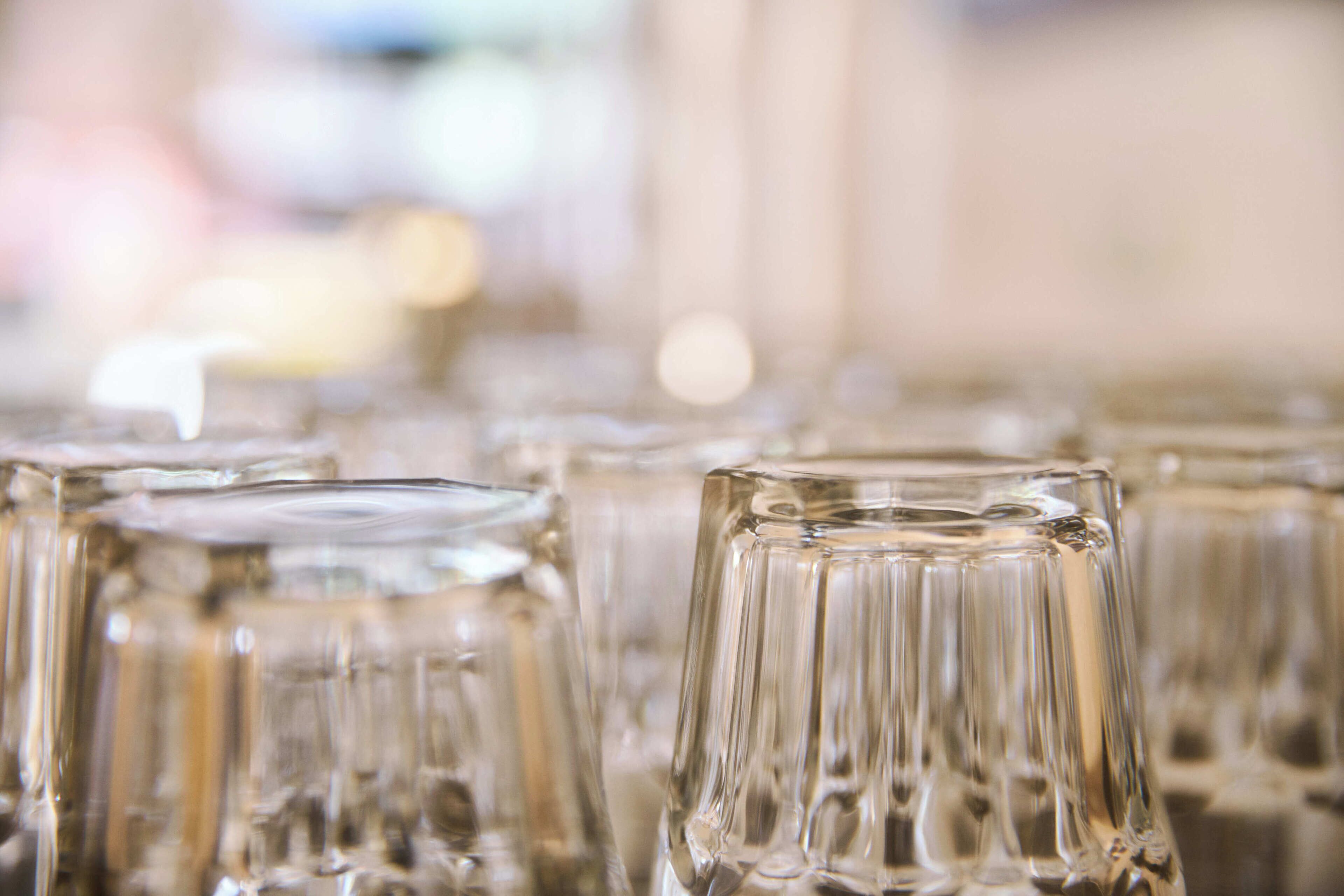 A close-up of multiple clear glass bottles with a textured surface, likely for holding beverages.