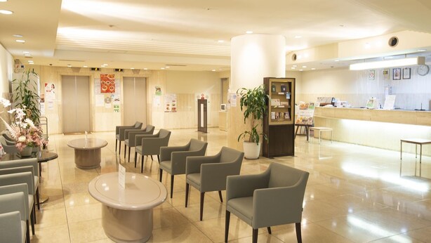 A hotel lobby with seating areas, a reception desk, and informational posters on the walls. - Grand Hotel Kanachu Hadano (Hadano)