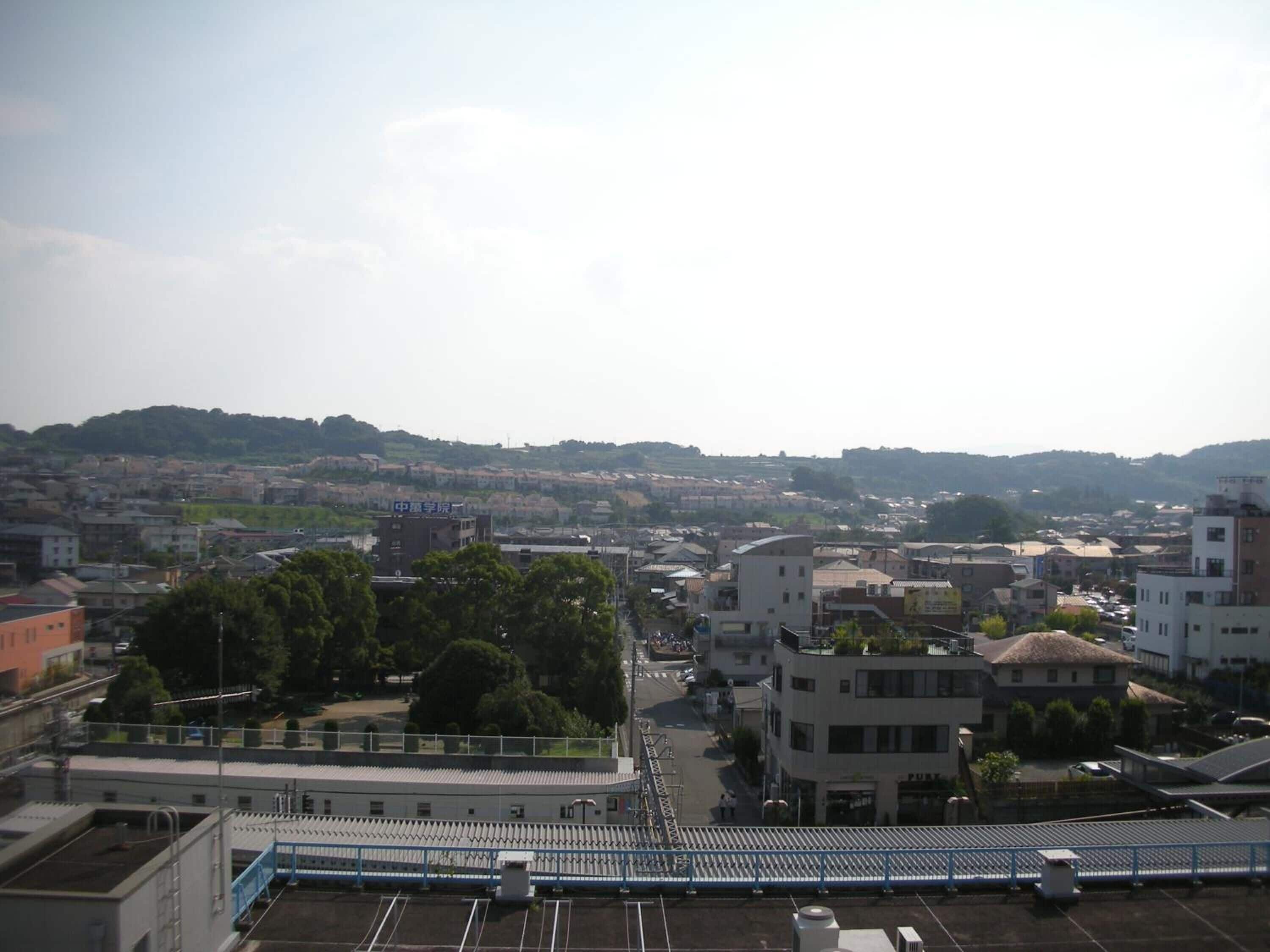 A cityscape with buildings, a bridge, and a distant hill.