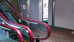 An escalator with a red handrail and a metal side panel. - Grand Hotel Kanachu Hadano (Hadano)