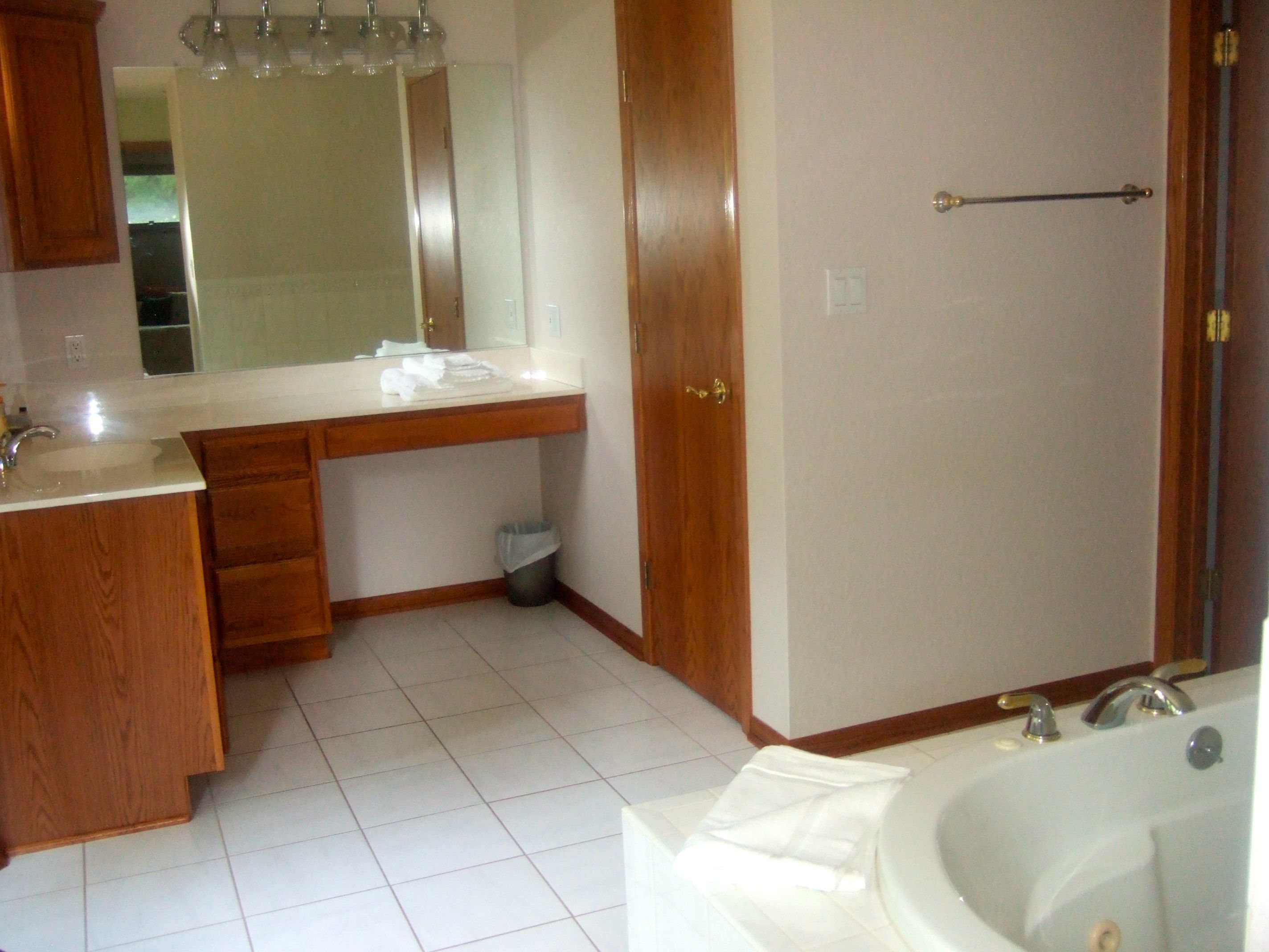 Un bagno con lavabo, specchio, mobile lavabo e vasca da bagno.