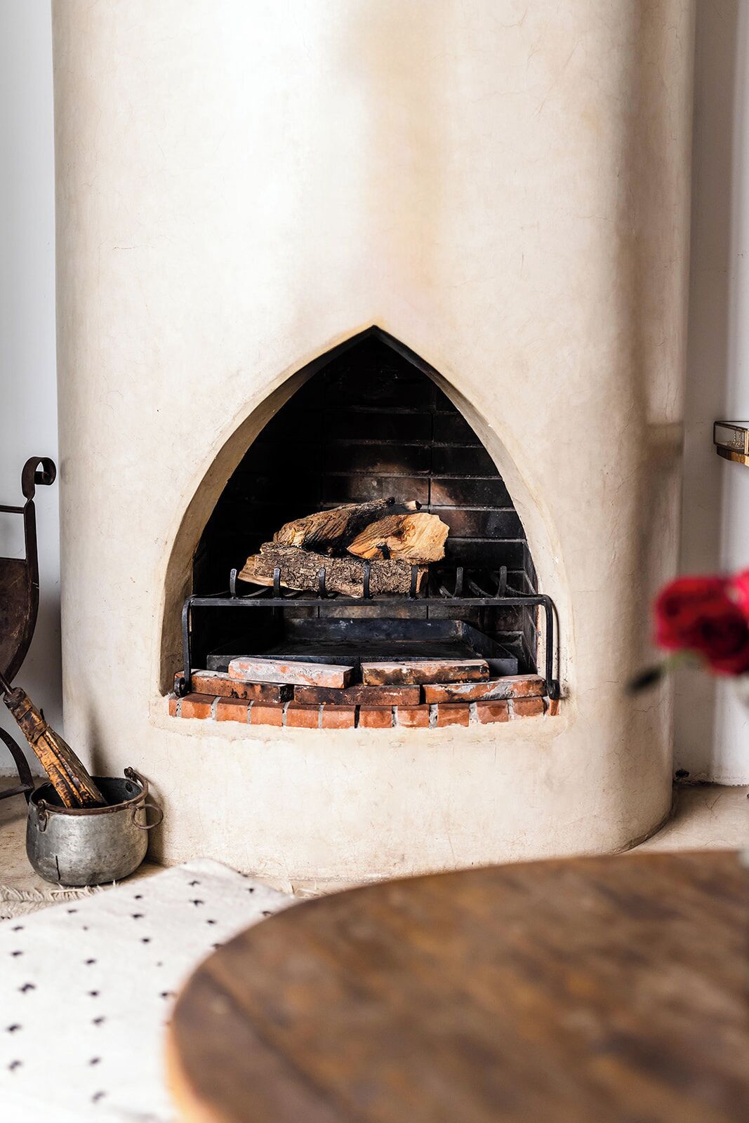 A stone fireplace with a brick base, a metal firebox, and a chimney.
