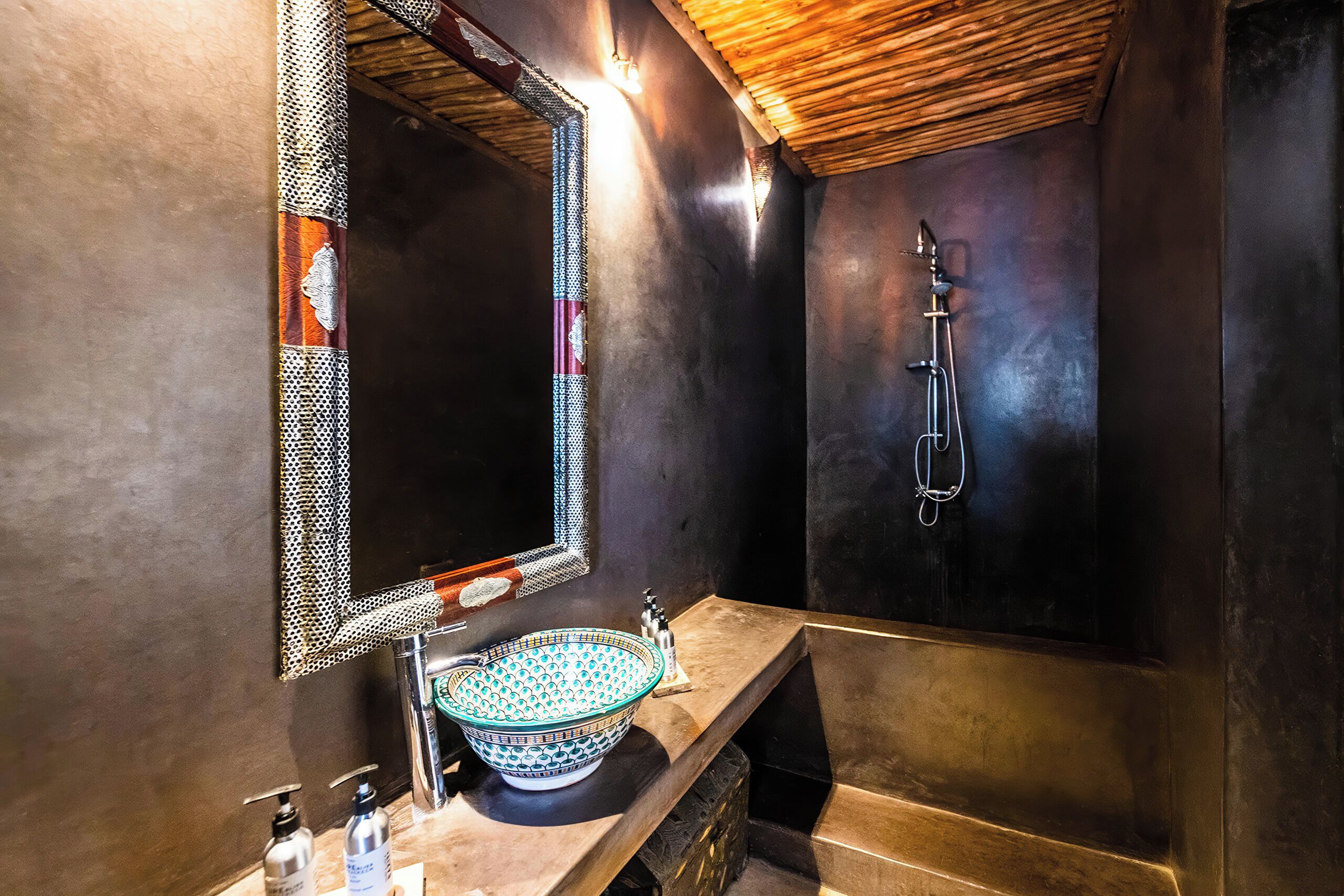 A modern bathroom with a large mirror, a vessel sink, and a shower.