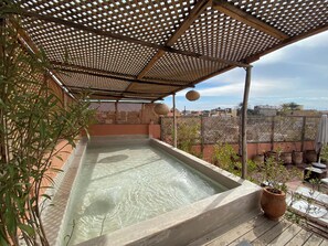 Una piscina al aire libre, sombrillas, sillones reclinables de piscina