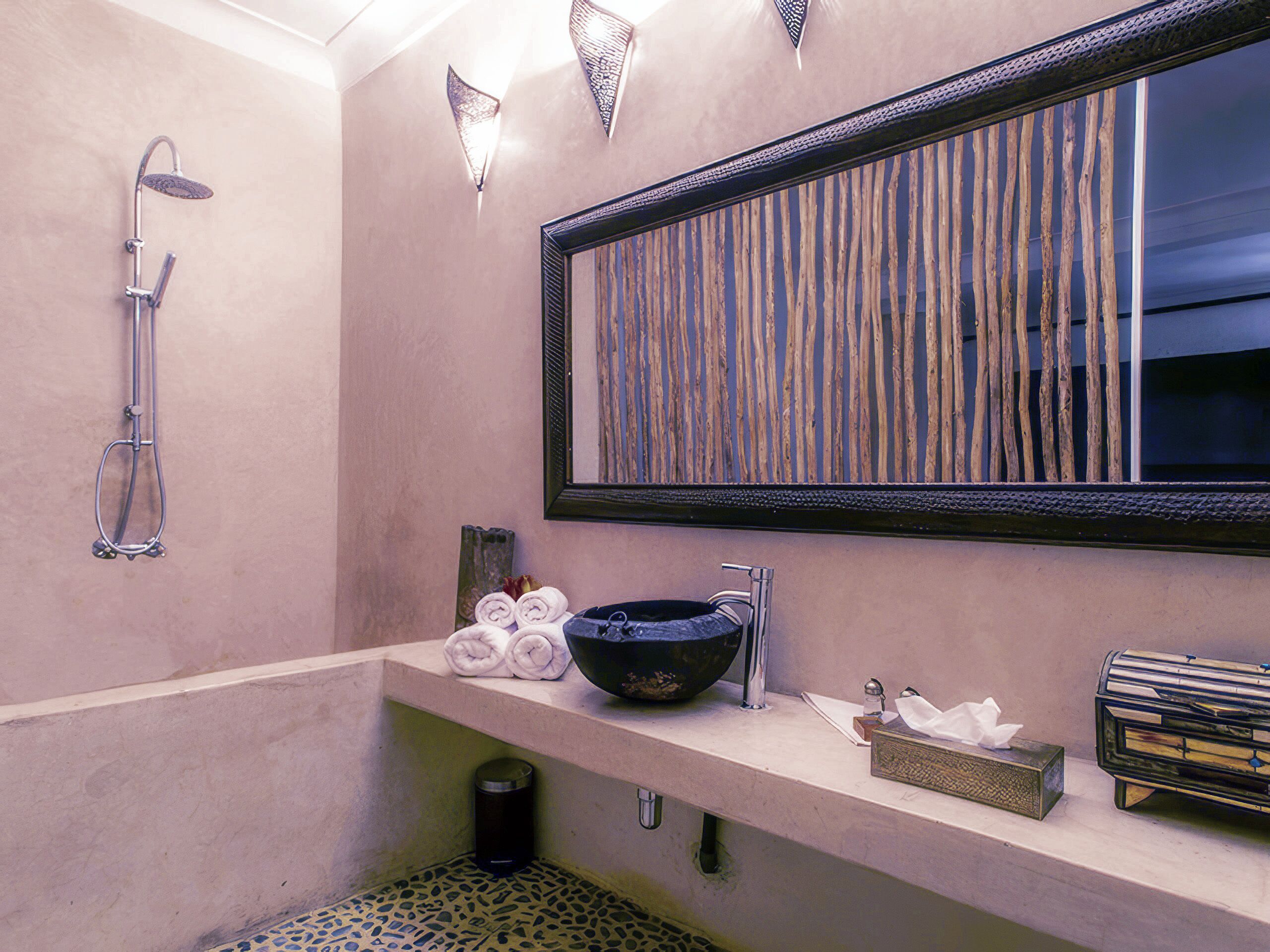 A modern bathroom with a shower, a large mirror, a sink, and a towel rack.