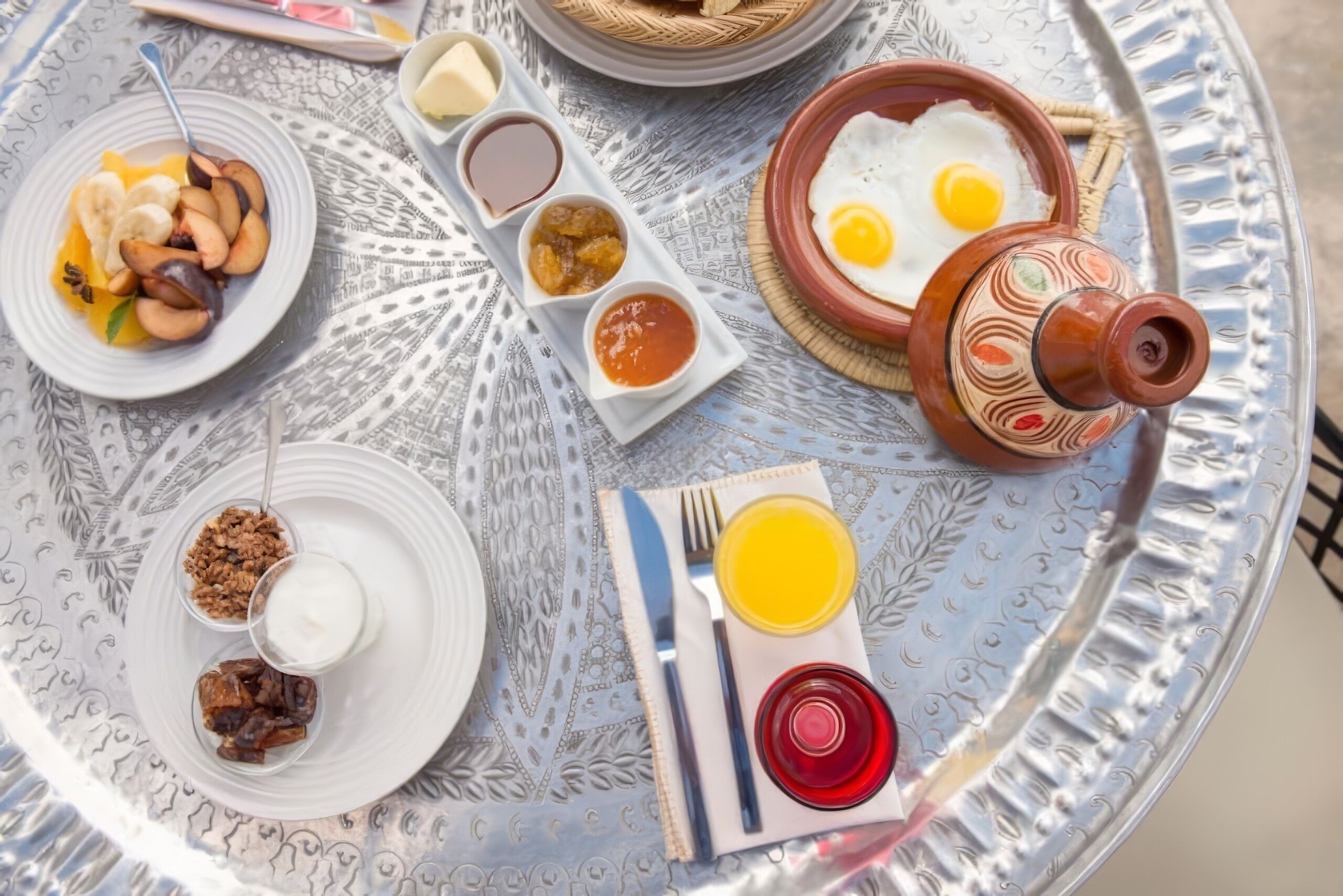 Bandeja de café da manhã com diversos pratos, incluindo ovos, frutas e acompanhamentos.