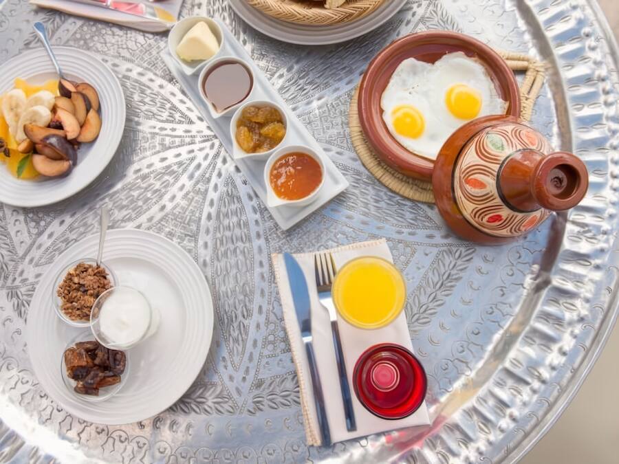 Bandeja de café da manhã com diversos pratos, incluindo ovos, frutas e acompanhamentos.