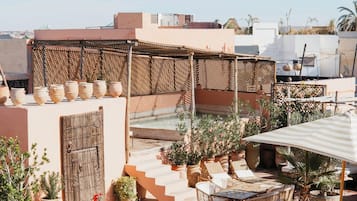 Una terrazza sul tetto con posti a sedere all'aperto, piante in vaso e vista sulla città.