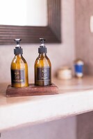 Dos botellas de jabón 'PURE BLISS' sobre una bandeja de madera en una encimera.