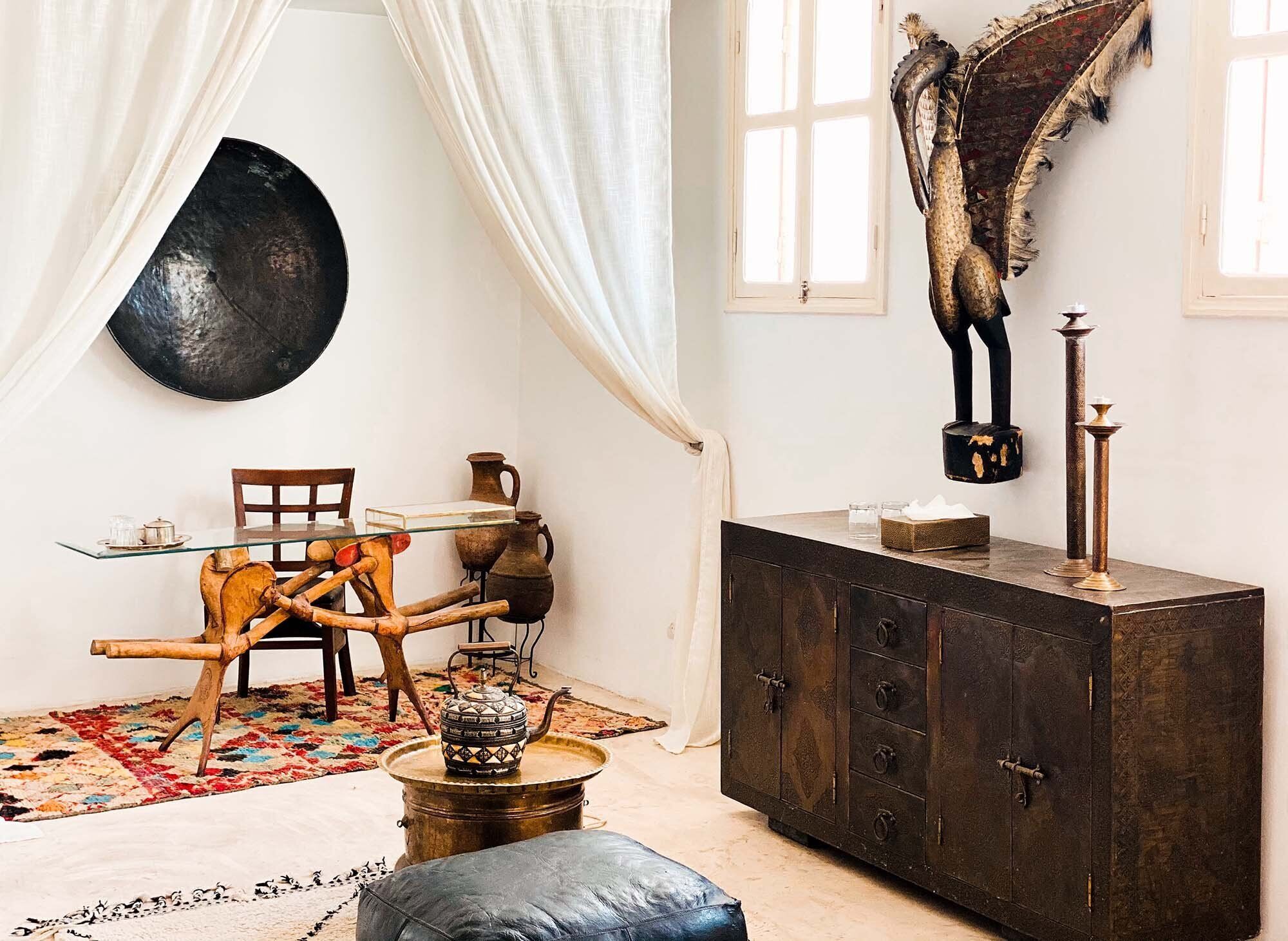 A room with a rustic wooden dining table, a dark cabinet, and a decorative horse head on the wall.