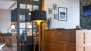 A modern kitchen with wooden cabinets, a marble countertop, and a large window. - Hôtel Restaurant Le Bellevue (La Bouille)
