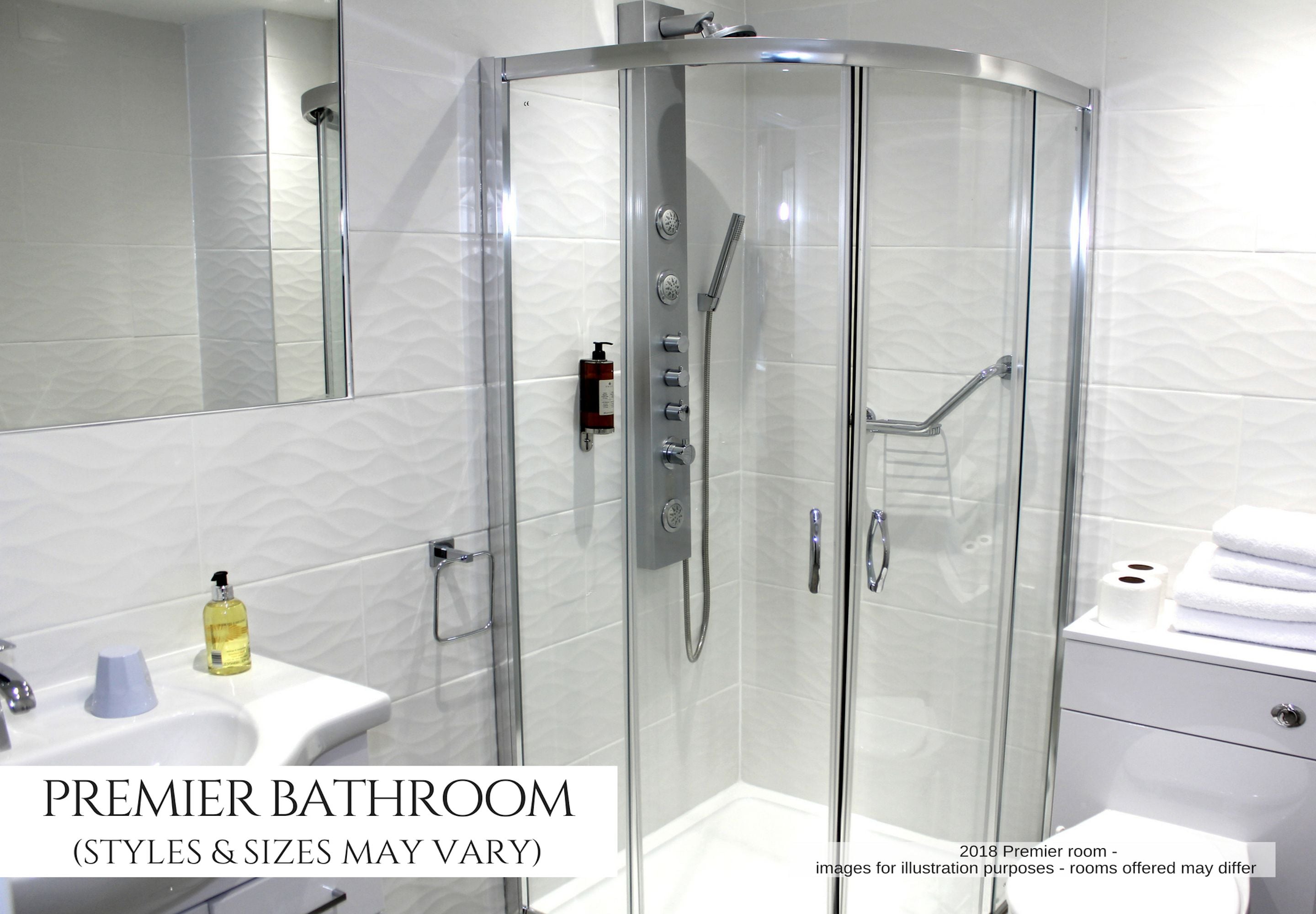 A modern bathroom with a glass-enclosed shower, a white sink, and a mirror.