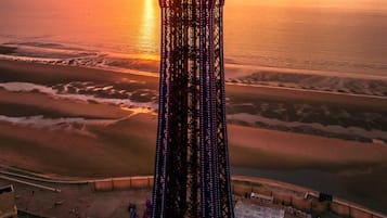 A tall tower with a complex structure, surrounded by a beach and ocean.
