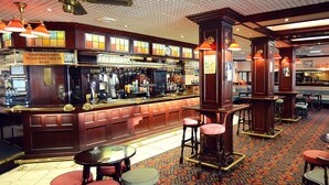A bar area with a food order point, multiple stools, and a patterned carpet. - Ruskin Hotel (Blackpool)