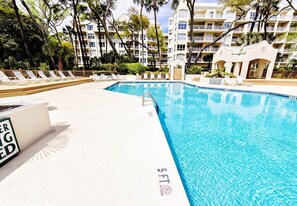 A swimming pool with lounge chairs and a sign indicating a 5 FT depth. - Sunset Escape 2 Bedroom Holiday Home (Hilton Head Island)