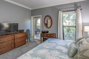 A bedroom with a bed, dresser, television, and a window with curtains. - Tresor Cache 2 Bedroom Holiday Home (Hilton Head Island)