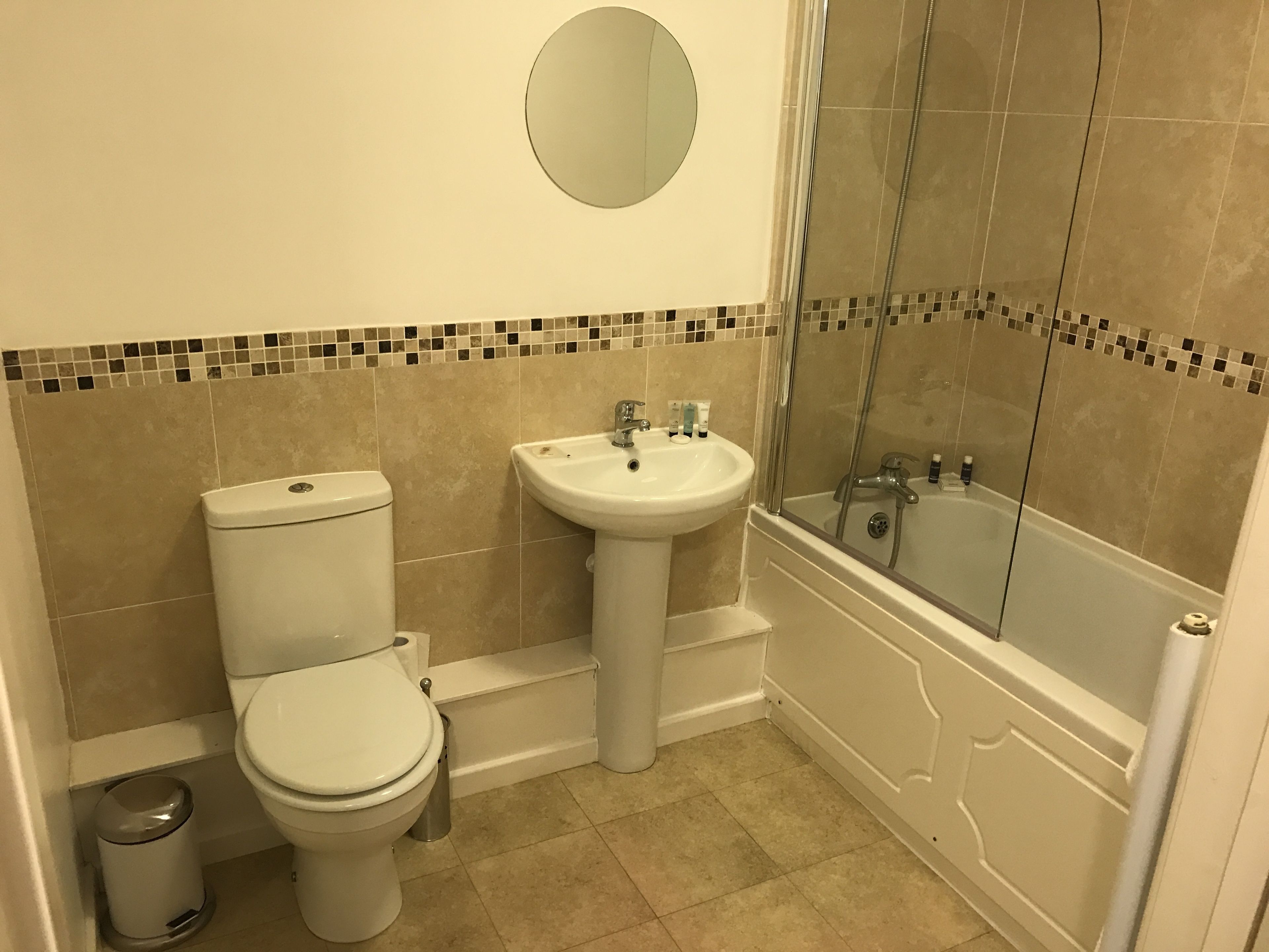 A bathroom with a toilet, sink, and glass-enclosed shower.