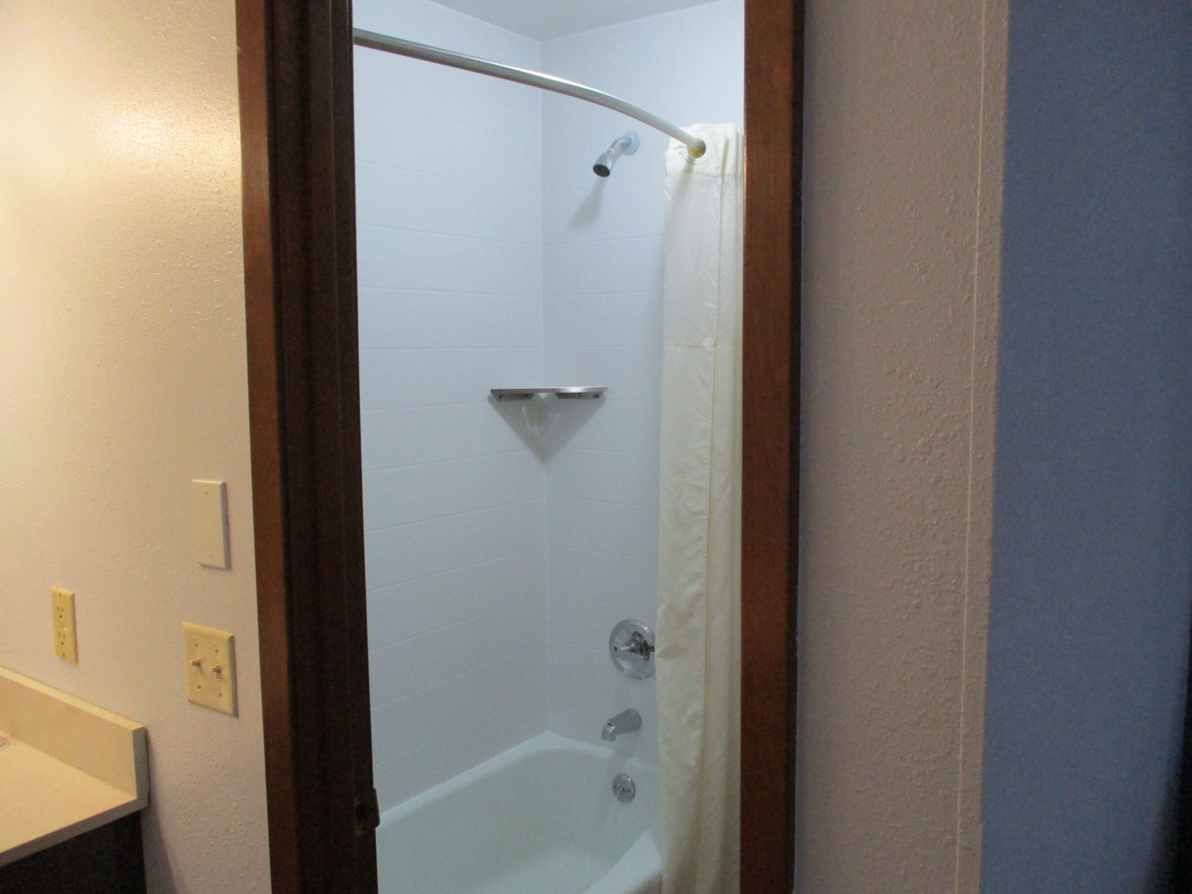 A bathroom with a shower, a bathtub, and a toilet.