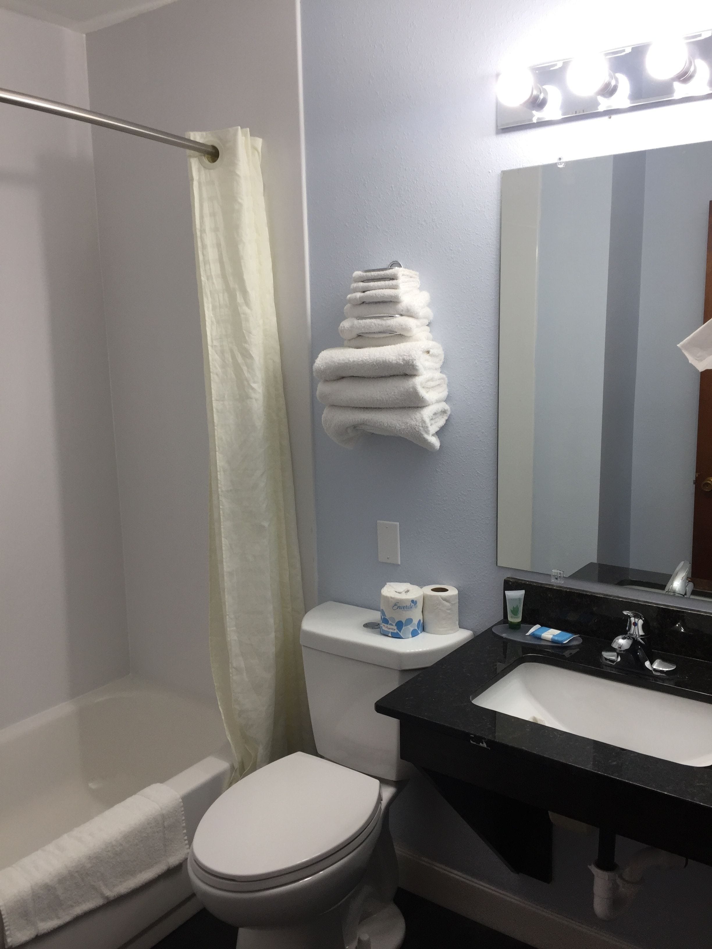Ein Badezimmer mit Dusche, Toilette, Waschbecken und Handtuchhalter.