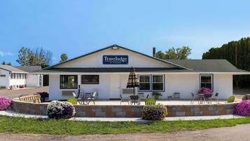 Guests can enjoy a welcoming patio area with outdoor seating and potted plants.