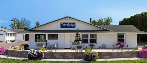 Et Travelodge by Wyndham med terrasse, udendørs møbler og en anlagt have.