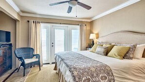 A hotel room with a bed, a chair, a ceiling fan, a TV, and a window with curtains. - 20 Sanddollar 3 Bedroom Holiday Home by Five Star Properties (Miramar Beach)