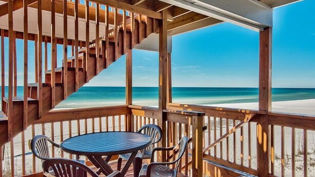 A wooden deck with a spiral staircase leading to a balcony overlooking a beach. - 20 Sanddollar 3 Bedroom Holiday Home by Five Star Properties (Miramar Beach)