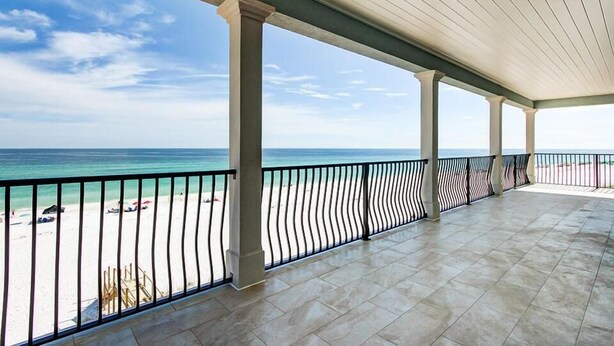 Ein überdachter Balkon mit Blick auf Strand und Meer.
