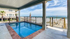 Ein Swimmingpool mit Blick auf den Strand und den Ozean.