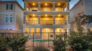 A multi-story hotel with balconies, a swimming pool, and a fenced courtyard. - Acqualina 9 Bedroom Holiday Home by Five Star Properties (Miramar Beach)
