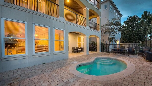 A two-story building with a swimming pool, outdoor seating, and a balcony with railing. - Acqualina 9 Bedroom Holiday Home by Five Star Properties (Miramar Beach)