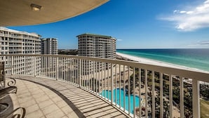 Un balcon avec vue sur une plage et une piscine.