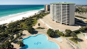 Un hôtel doté d’une grande piscine, d’une plage et offrant une vue sur l’océan.