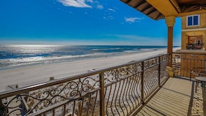A beach view from a balcony with a railing, a wooden deck, and a building with a balcony. - Bella Luna 4 Bedroom Holiday Home by Five Star Properties (Destin)