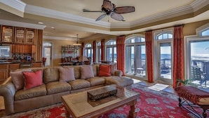 A spacious living room with a large sofa, a coffee table, and a view of the ocean through large windows. - Bella Luna 4 Bedroom Holiday Home by Five Star Properties (Destin)