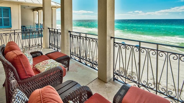A covered balcony with wicker furniture and a view of the ocean. - Bella Vizio 5 Bedroom Holiday Home by Five Star Properties (Miramar Beach)