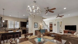 Un amplio espacio de sala con una mesa de comedor, sofás y un televisor.