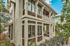 A two-story house with a balcony and large windows.