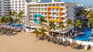A hotel with multiple floors, a swimming pool, and palm trees. - Star Palace Hotel (Mazatlán)