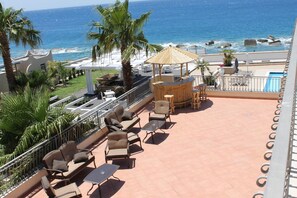 A rooftop terrace with outdoor seating, a pool, and a view of the ocean. - Le Saline Resort (Montebello Ionico)