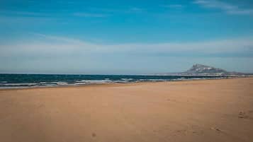 On the beach, white sand, sun-loungers, beach umbrellas