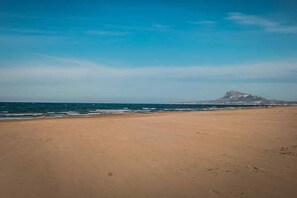 On the beach, white sand, sun-loungers, beach umbrellas