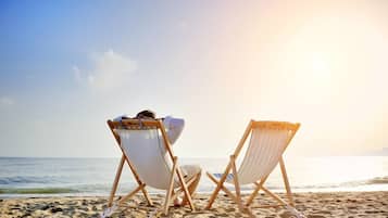 On the beach, white sand, sun-loungers, beach umbrellas