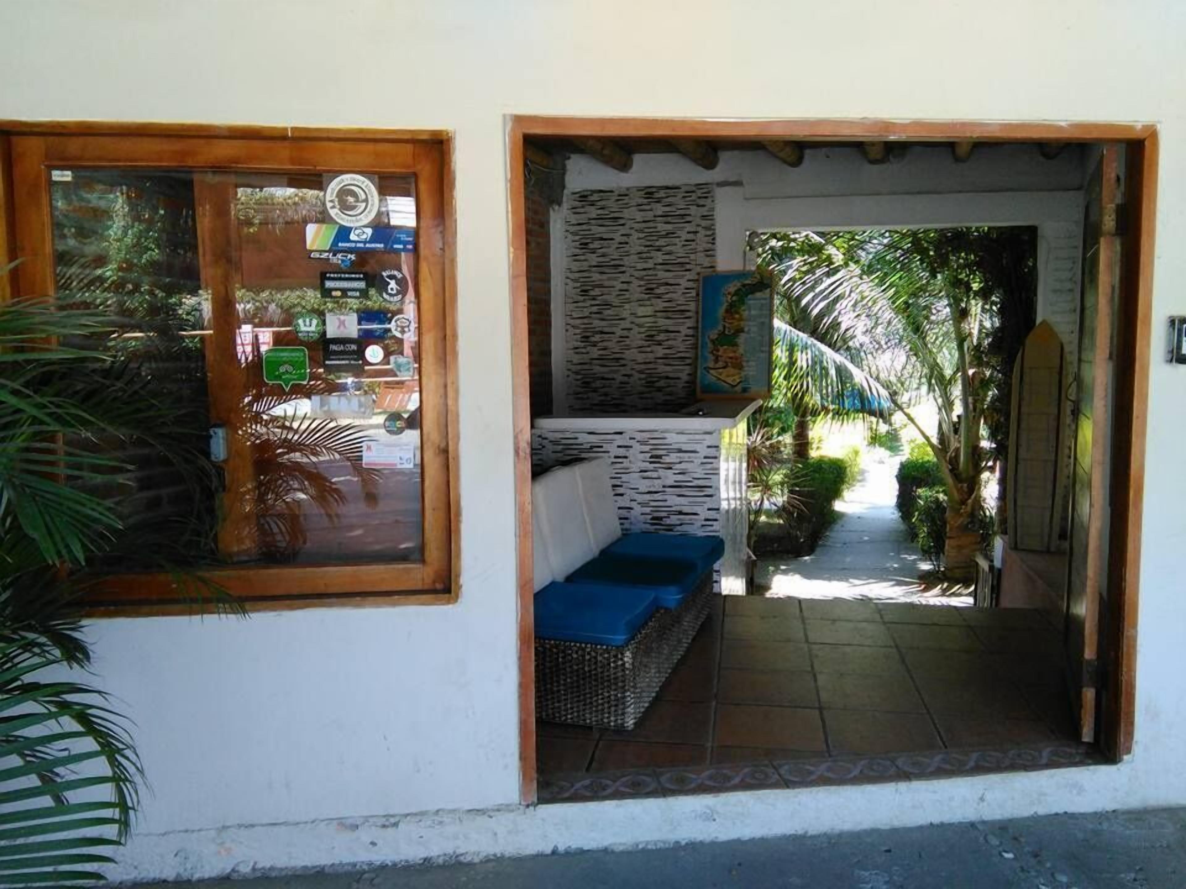 Un sendero estrecho que lleva a un edificio con una puerta de madera y una ventana con pegatinas.