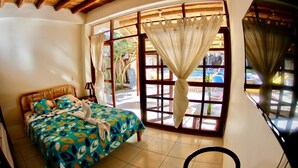 Ein Schlafzimmer mit Bett, Stuhl und einem fensterbepflanzten Fenster.