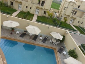 Piscina externa, guarda-sóis, espreguiçadeiras