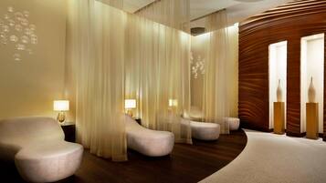 A modern hotel lobby with a curved carpet, plush seating, and ambient lighting.