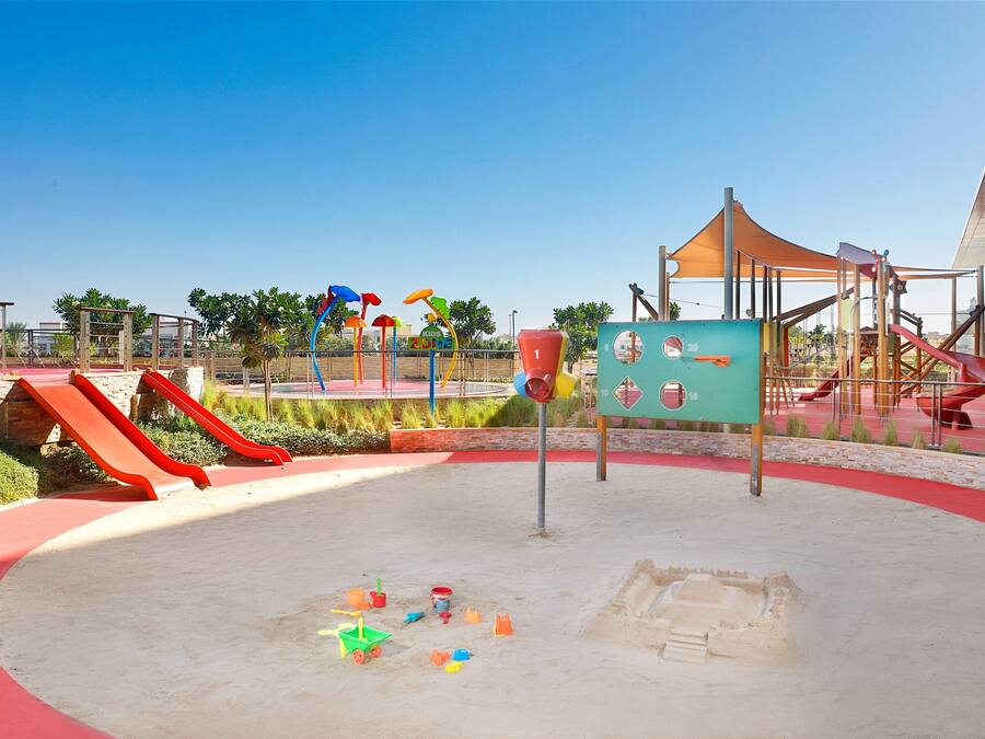 A playground with slides, climbing structures, and a sandpit.