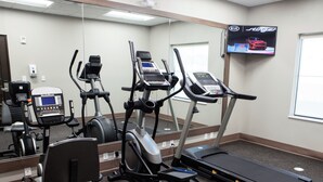 A gym with treadmills, elliptical machines, and a stationary bike. - Days Inn & Suites by Wyndham Houston NW Cypress (Houston)